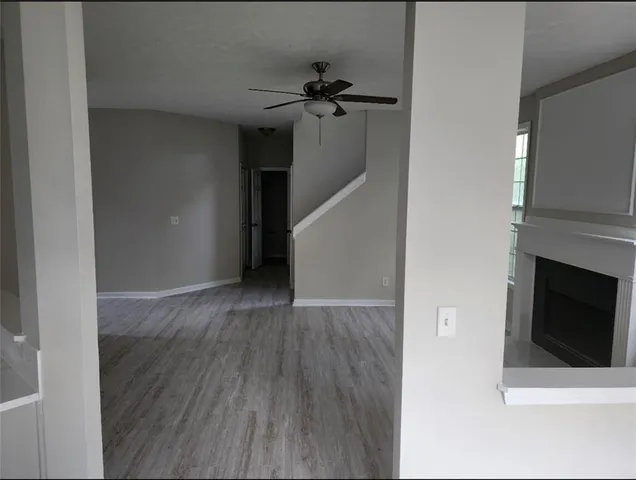 a view of a livingroom with wooden floor and a ceiling fan