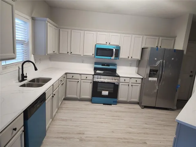 a kitchen with stainless steel appliances granite countertop a sink stove and refrigerator