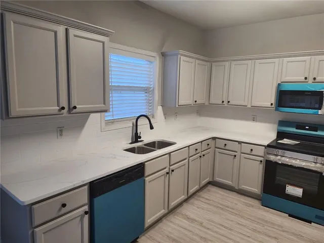 a kitchen with a sink cabinets and stainless steel appliances