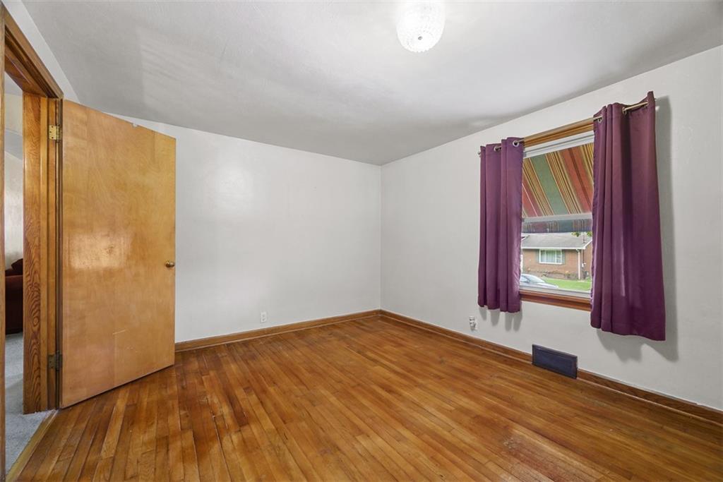 1233 Virginia Avenue Midland, PA 15059 - Photo 22 of 44 a view of an empty room with wooden floor and a window