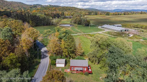 a aerial view of a house with a garden and mountains