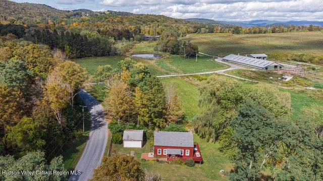 a aerial view of a house with a garden and mountains