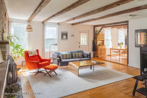 a living room with patio furniture and a rug