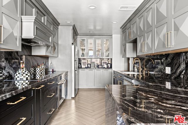 a kitchen with stainless steel appliances granite countertop a stove and cabinets