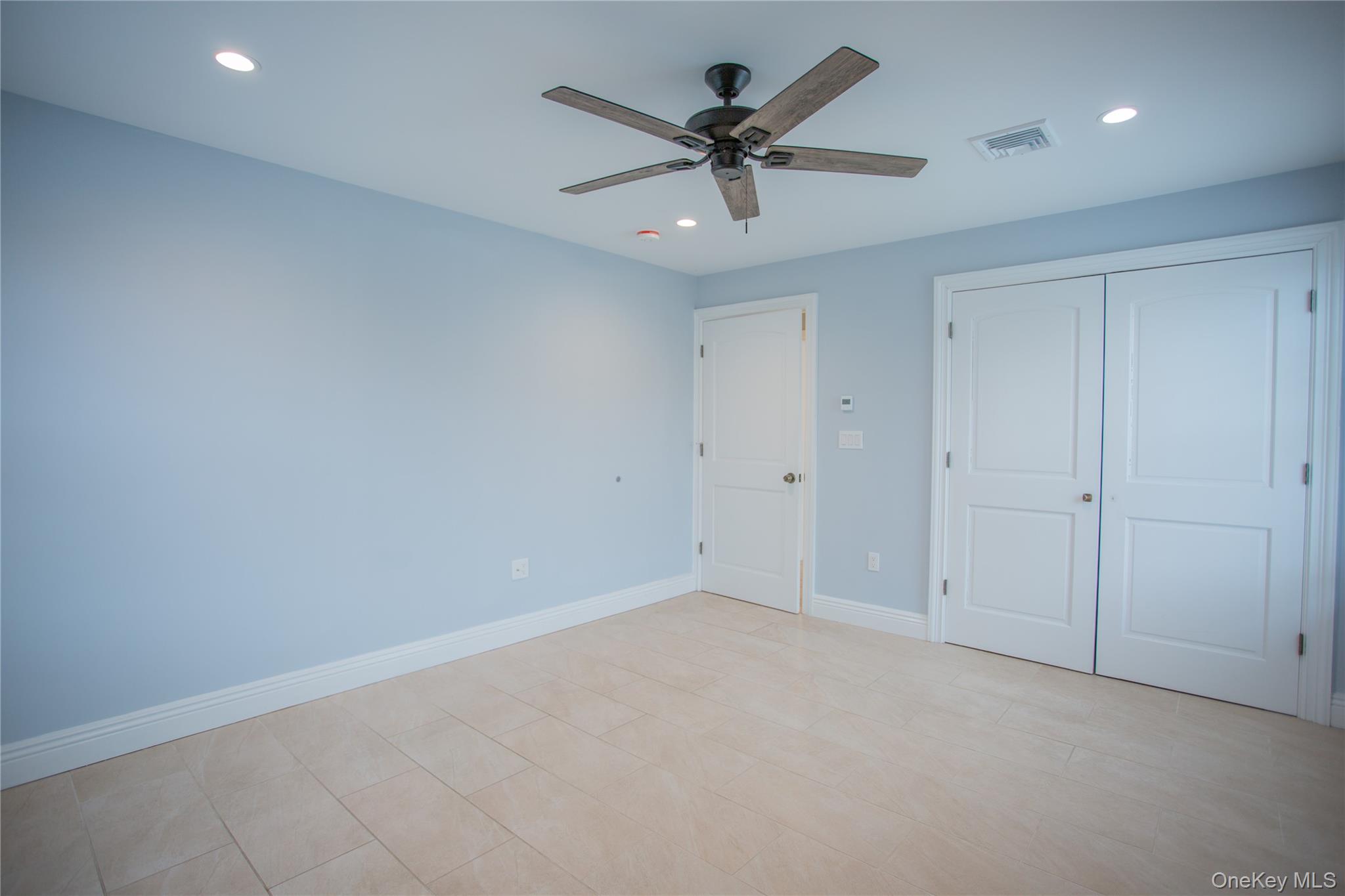 59 Clinton Avenue Inwood, NY 11096 - Photo 13 of 19 an empty room with ceiling fan and window