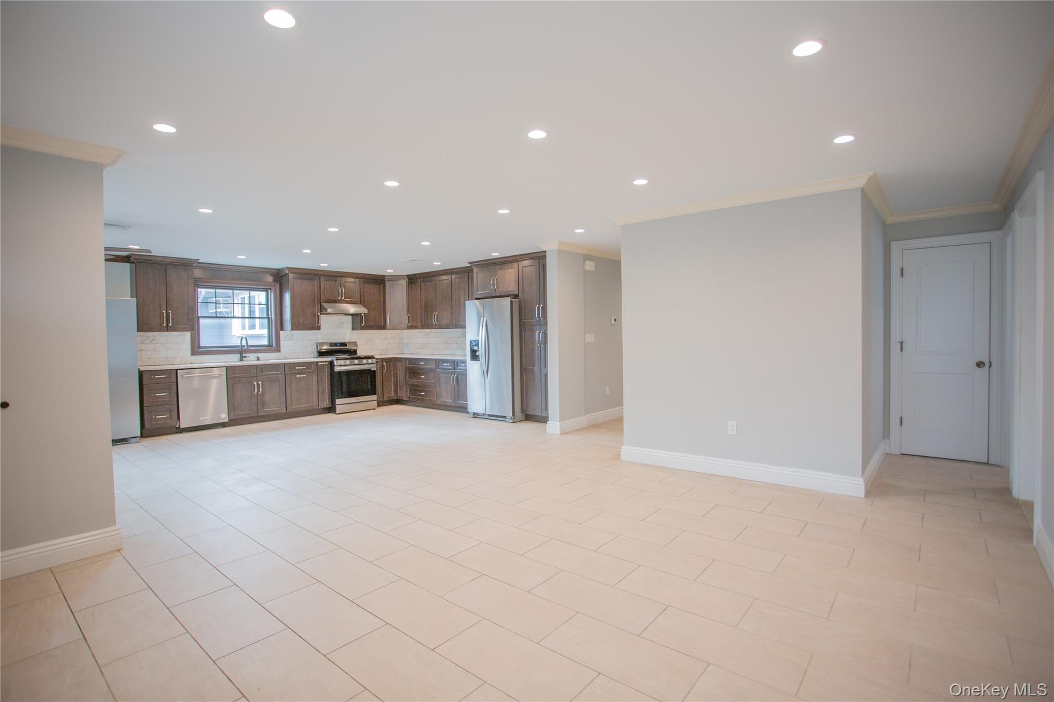 59 Clinton Avenue Inwood, NY 11096 - Photo 2 of 19 a view of a kitchen with a sink and a refrigerator in a room
