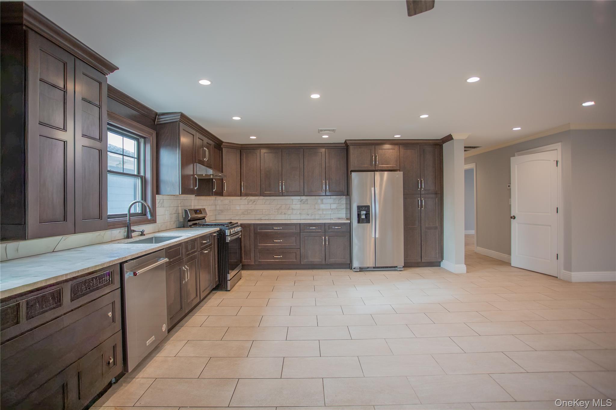59 Clinton Avenue Inwood, NY 11096 - Photo 4 of 19 a large kitchen with stainless steel appliances lots of counter top space cabinets and a sink