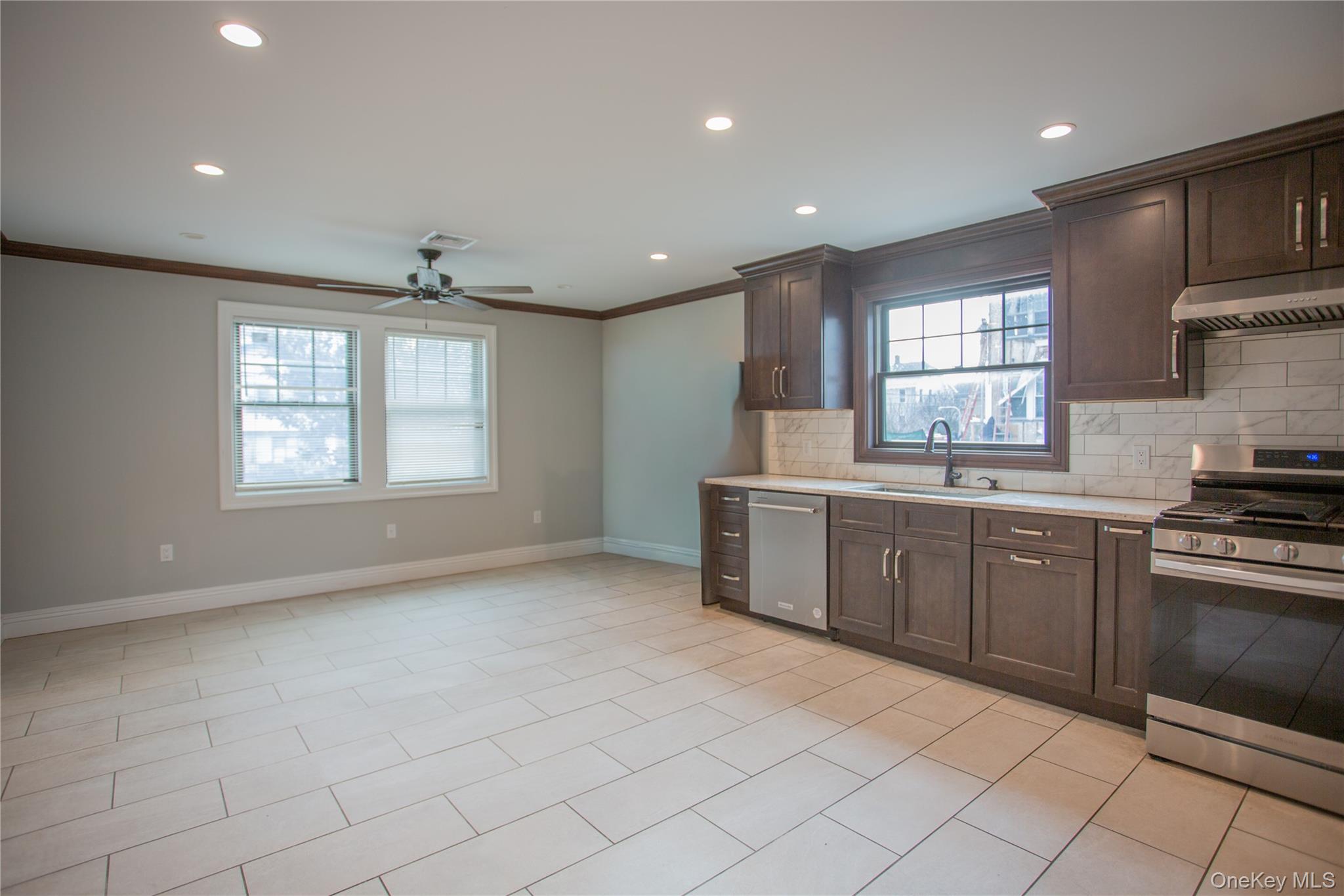 59 Clinton Avenue Inwood, NY 11096 - Photo 5 of 19 a kitchen with a sink window and cabinets