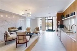 a large living room with stainless steel appliances furniture a couch and a large window