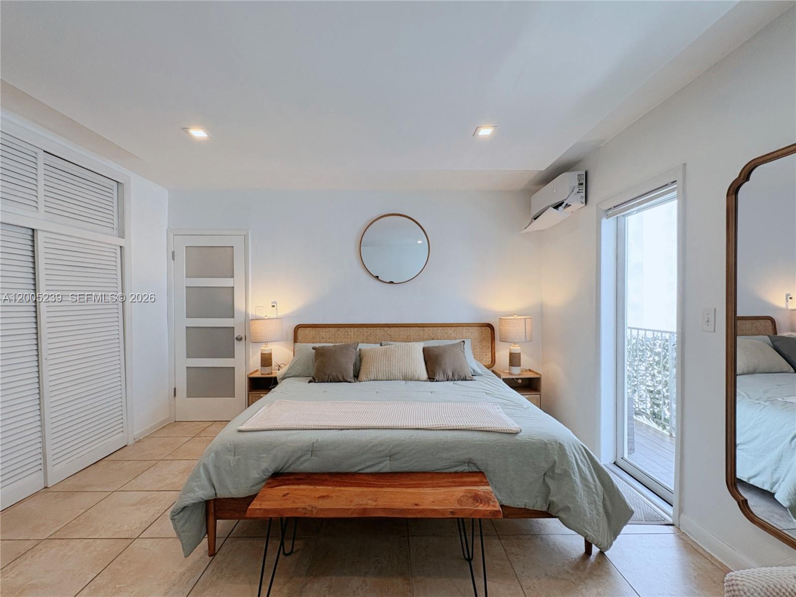 944 Meridian Avenue, Unit 11 Miami Beach, FL 33139 - Photo 11 of 14 a bedroom with a large bed and a chandelier
