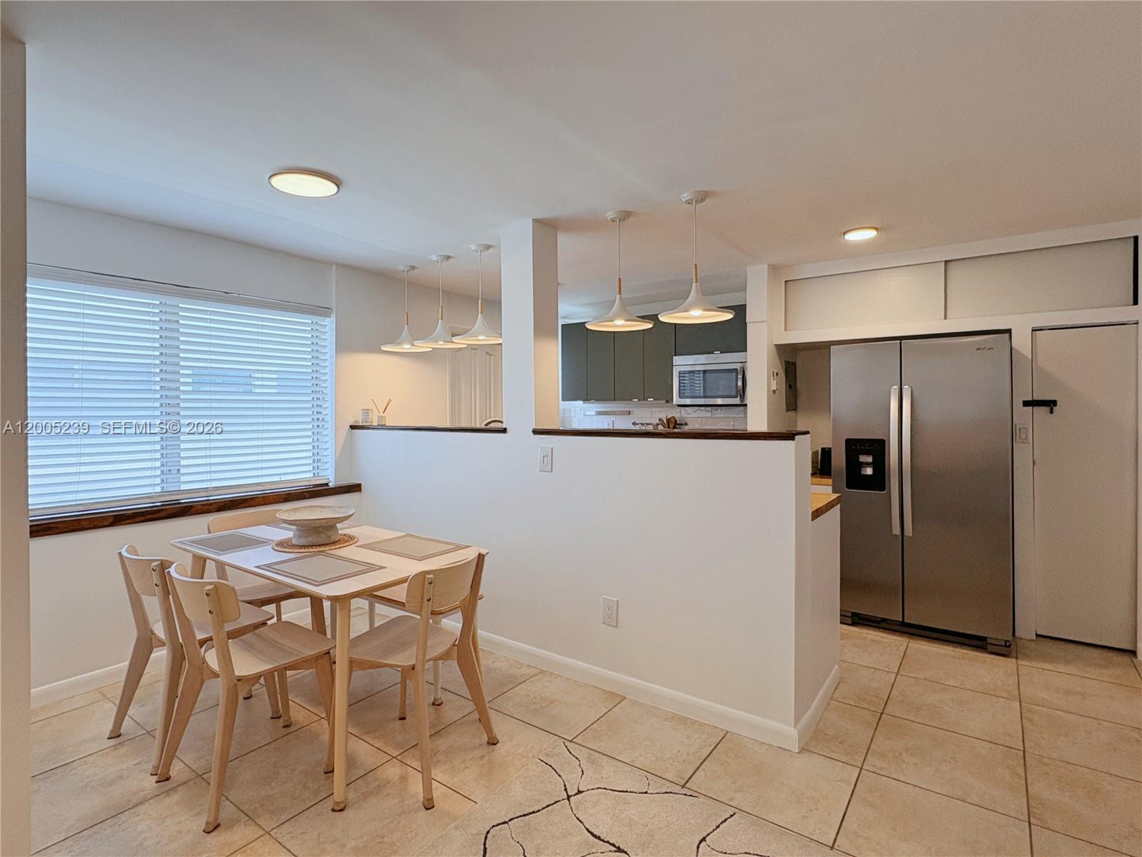 944 Meridian Avenue, Unit 11 Miami Beach, FL 33139 - Photo 5 of 14 a kitchen with stainless steel appliances kitchen island granite countertop a refrigerator and a stove top oven