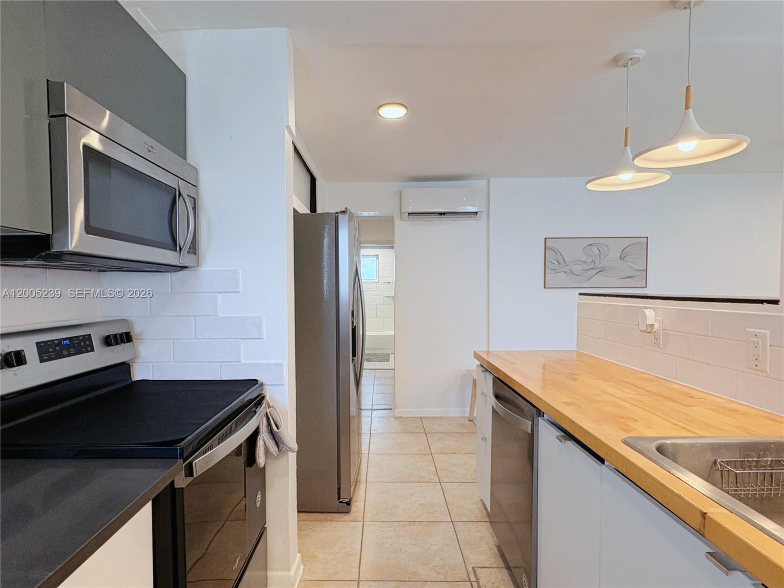944 Meridian Avenue, Unit 11 Miami Beach, FL 33139 - Photo 8 of 14 a kitchen with a sink a counter top space cabinets and stainless steel appliances