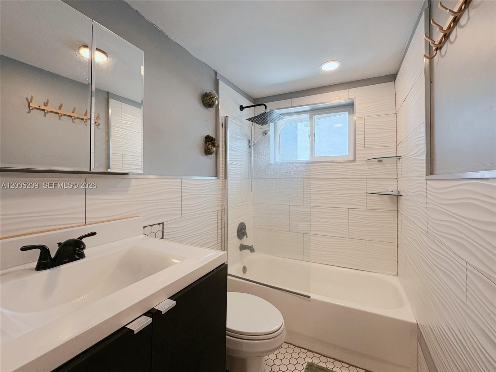 944 Meridian Avenue, Unit 11 Miami Beach, FL 33139 - Photo 9 of 14 a bathroom with a sink a toilet and shower