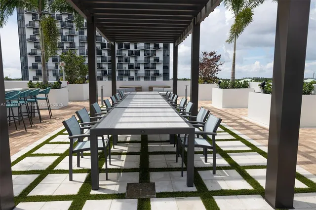 a view of a patio with a table chairs and a floor to ceiling window