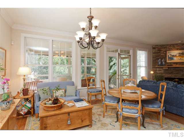 1909 Torrington Street Raleigh, NC 27615 - Photo 9 of 25 a dining room with wooden floor a chandelier a glass table and chairs