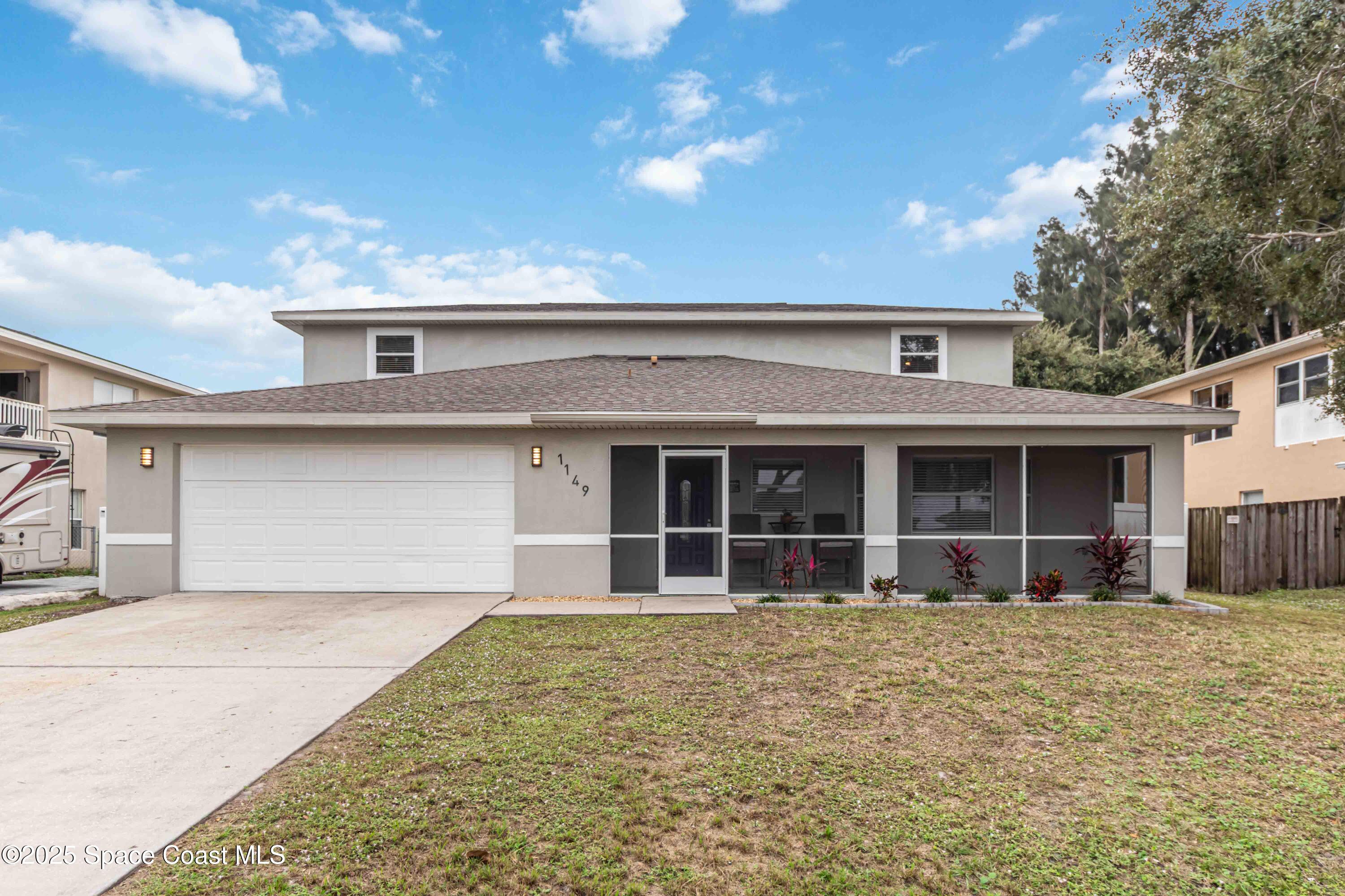 1149 Scyphers Street Northeast Palm Bay, FL 32905 - Photo 2 of 39 front view of a house with a yard