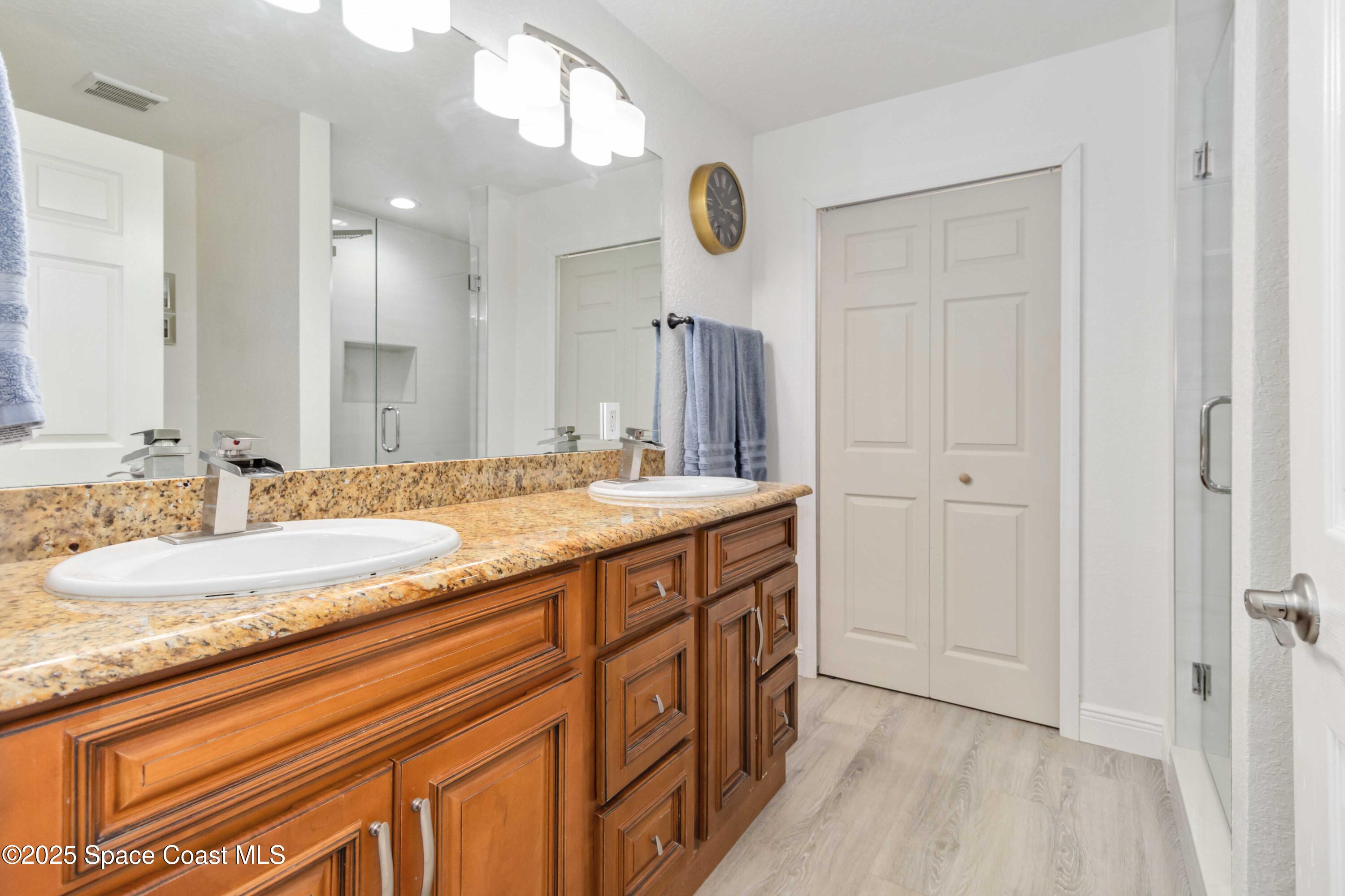 1149 Scyphers Street Northeast Palm Bay, FL 32905 - Photo 28 of 39 a bathroom with a granite countertop sink and a mirror