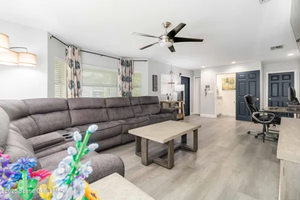 a living room with furniture and a chandelier