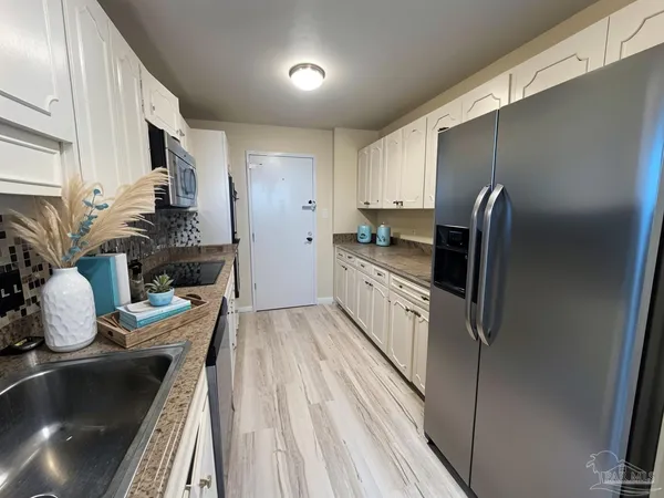 a kitchen with kitchen island granite countertop a sink stove and refrigerator