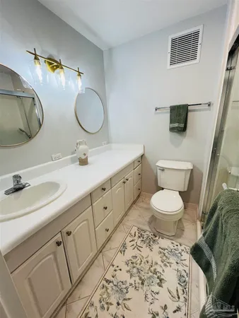 a bathroom with a toilet sink double vanity and mirror