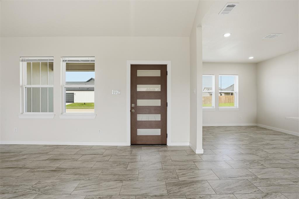532 Highview Court Godley, TX 76044 - Photo 6 of 39 Spacious entryway featuring a modern wood-finish door with frosted glass inserts, light gray tile flooring, recessed lighting, and white walls