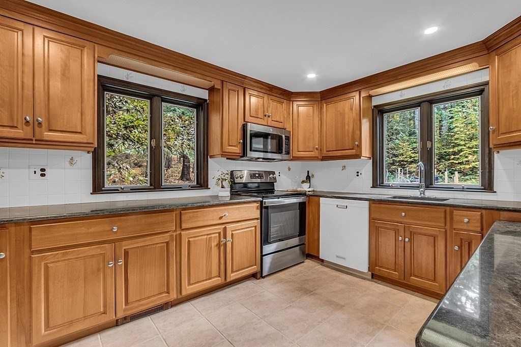 3 Peninsula Road Harvard, MA 01451 - Photo 16 of 42 a kitchen with granite countertop wooden cabinets a stove a sink and a window