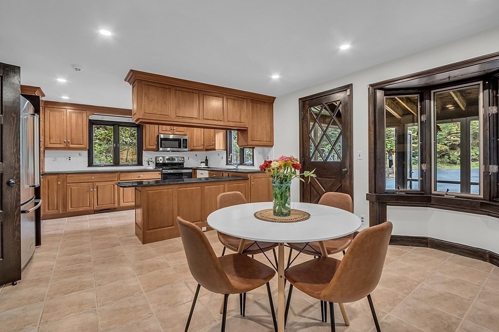 3 Peninsula Road Harvard, MA 01451 - Photo 17 of 42 a kitchen with a dining table chairs and stove