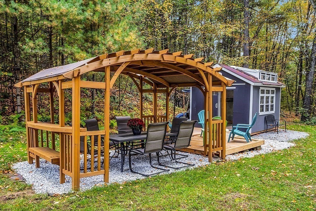 3 Peninsula Road Harvard, MA 01451 - Photo 31 of 42 a view of a chair and table in the back yard of the house
