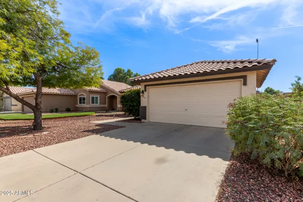a view of a house with a yard and a garage