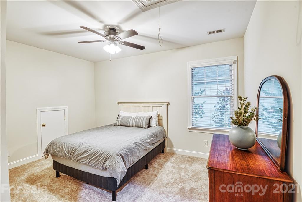 1380 Barnett Woods Fort Mill, SC 29708 - Photo 25 of 31 a bedroom with a large bed and a chandelier