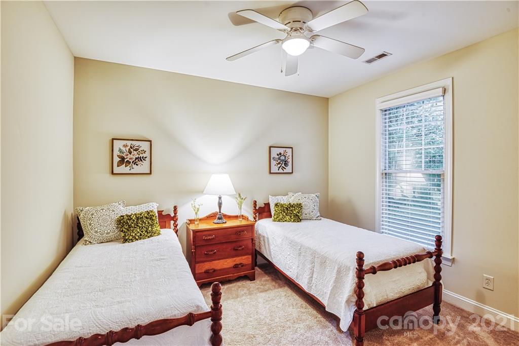 1380 Barnett Woods Fort Mill, SC 29708 - Photo 26 of 31 a bedroom with a bed and a chandelier