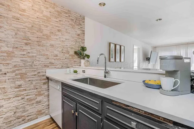 a kitchen with a sink and a stove with white countertops