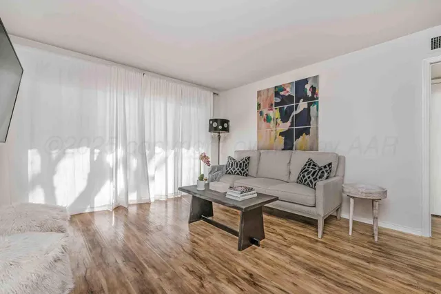 a living room with furniture and a wooden floor
