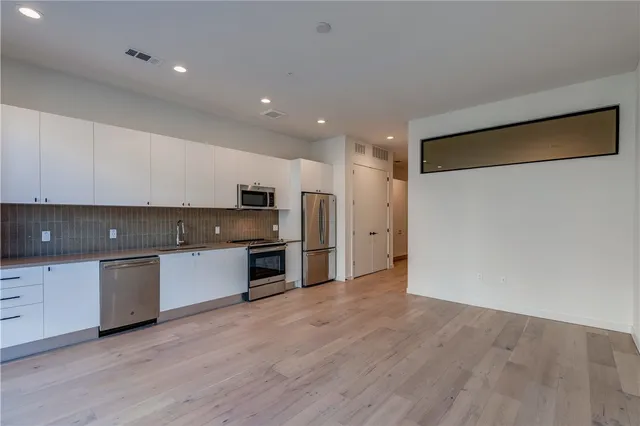 a kitchen with stainless steel appliances granite countertop a stove a sink and a refrigerator