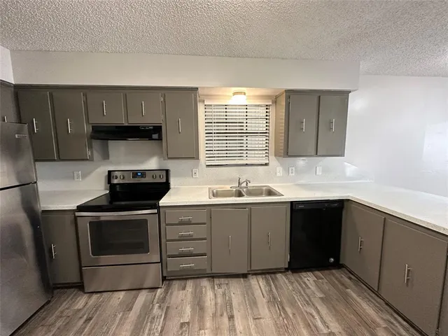 a kitchen with a sink stove and cabinets