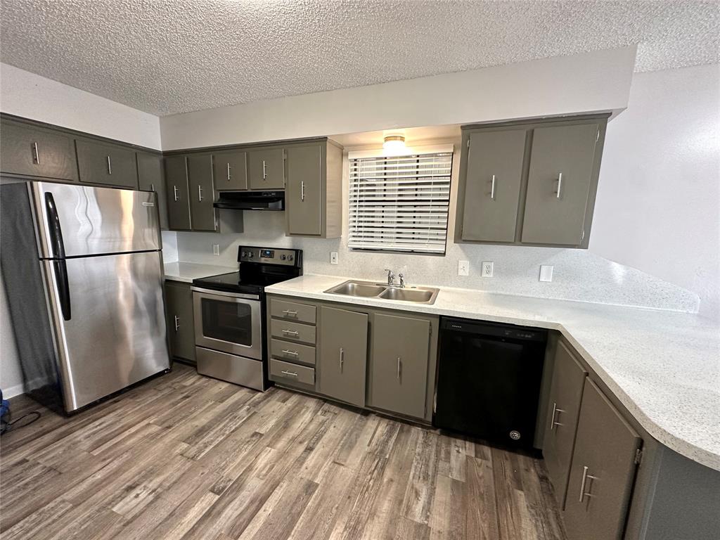 2006 Jane Street, Unit F Longview, TX 75601 - Photo 5 of 9 a kitchen with a refrigerator sink and cabinets