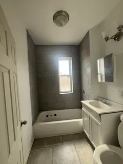 a bathroom with a tub sink toilet and mirror