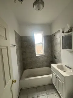 a bathroom with a tub a sink and a shower
