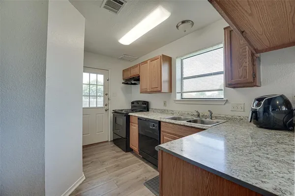 a kitchen with a stove a sink and a window