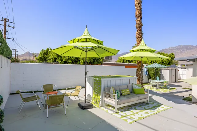 a view of tall building with two chair and a potted plant