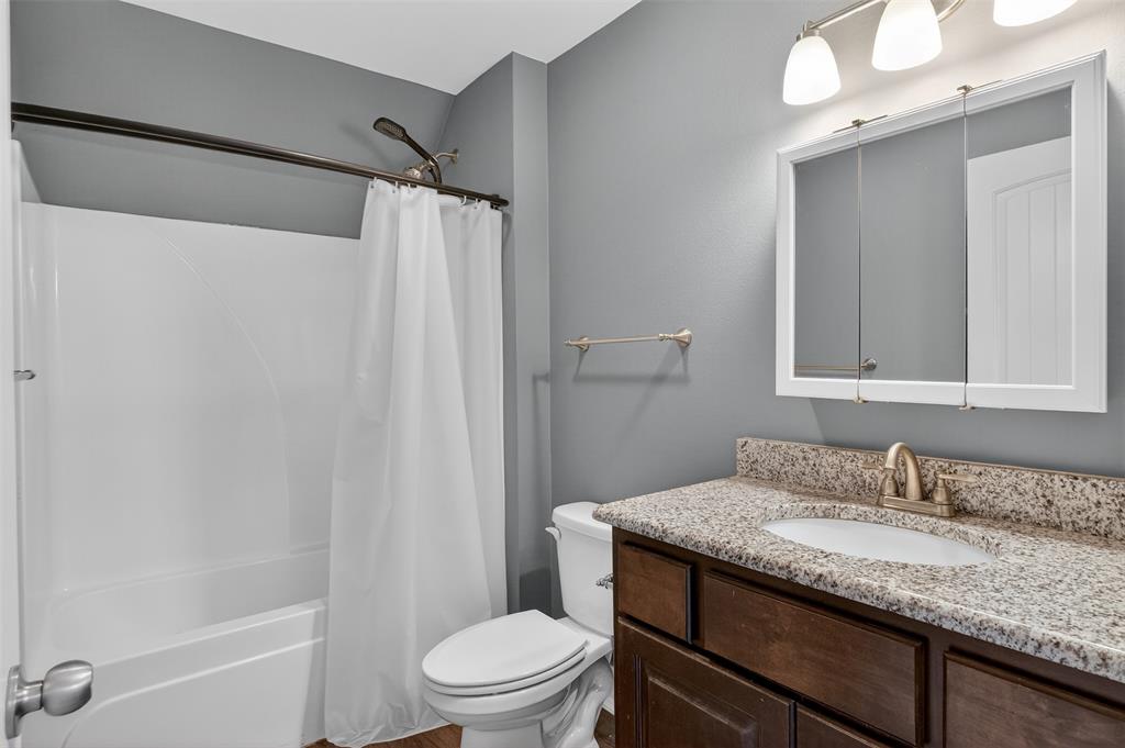 720 Haggerty Road Karnack, TX 75661 - Photo 24 of 39 a bathroom with a granite countertop sink toilet and shower