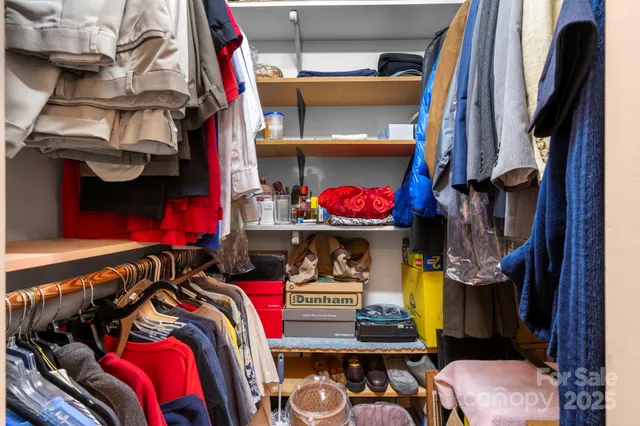 a bedroom with a bed and a lamp on dresser