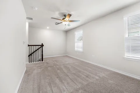 an empty room with a ceiling fan and a window