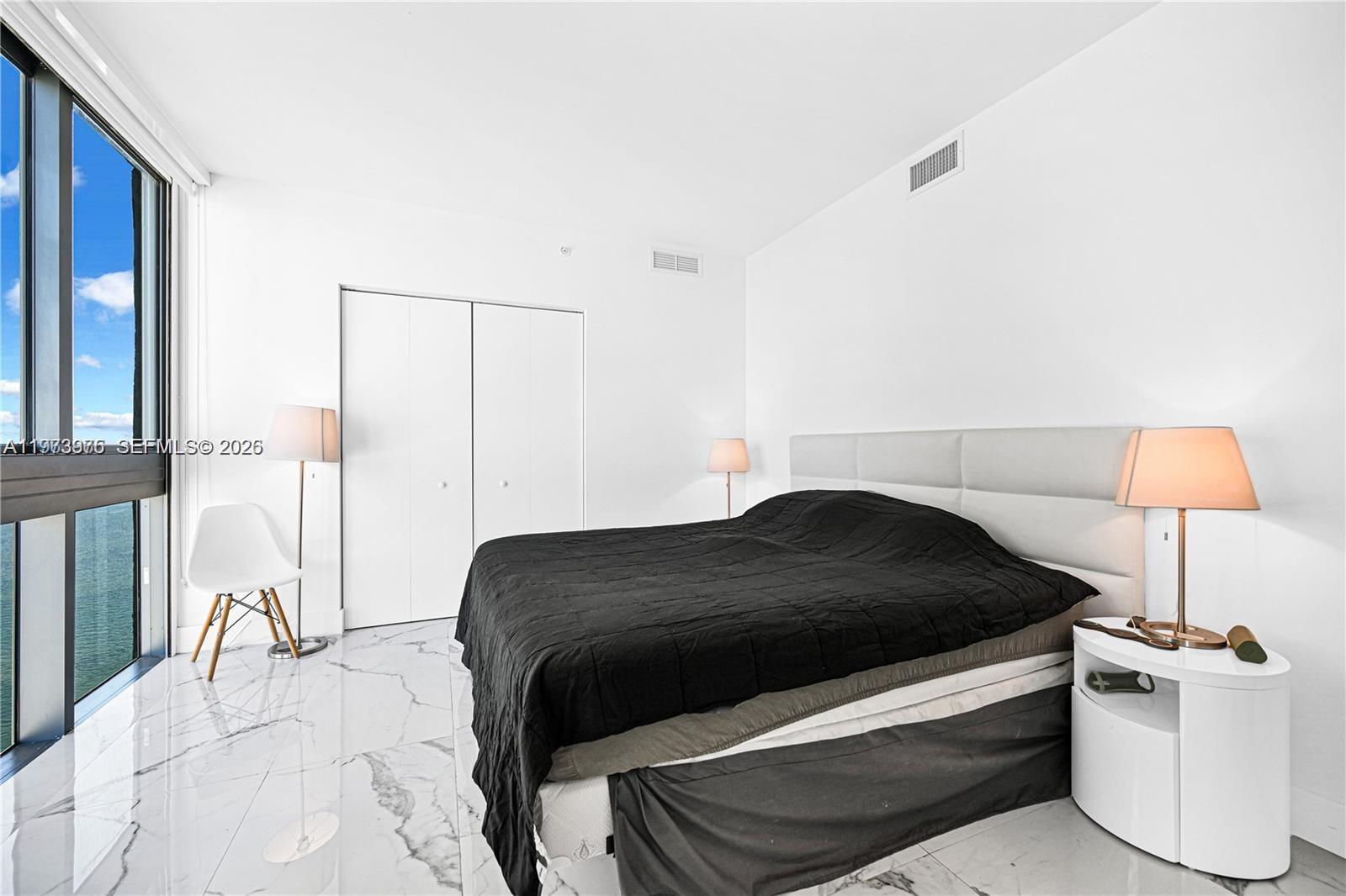 650 Northeast 32nd Street, Unit 2007 Miami, FL 33137 - Photo 11 of 44 a bedroom with a bed and a lamp