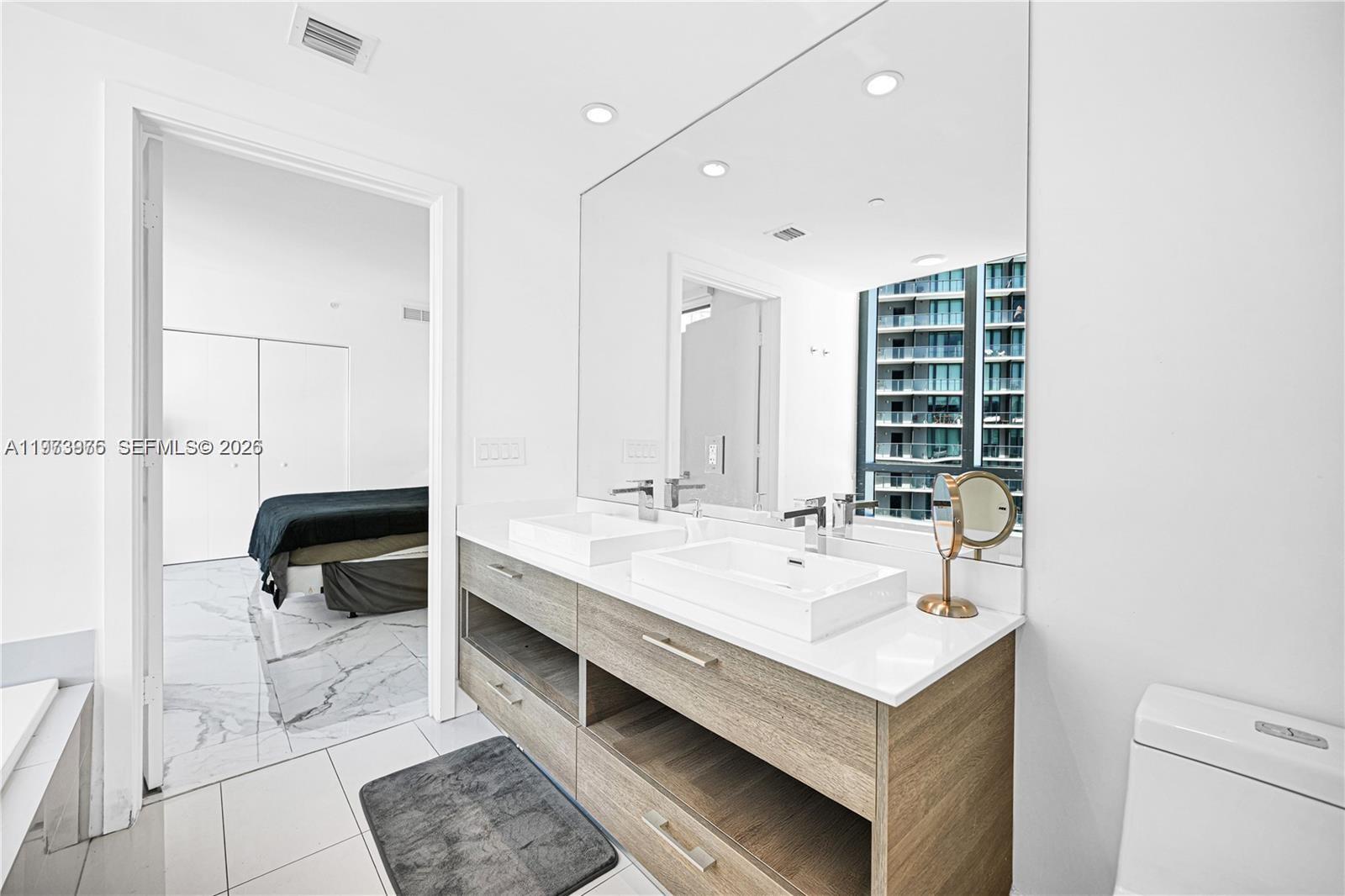 650 Northeast 32nd Street, Unit 2007 Miami, FL 33137 - Photo 15 of 44 a bathroom with a sink and a mirror