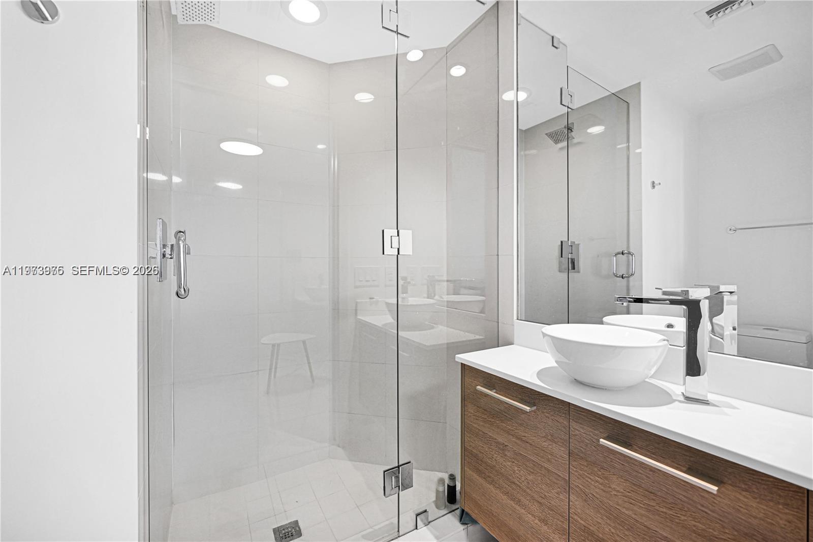650 Northeast 32nd Street, Unit 2007 Miami, FL 33137 - Photo 19 of 44 a bathroom with a double vanity sink mirror double shower and a bathtub