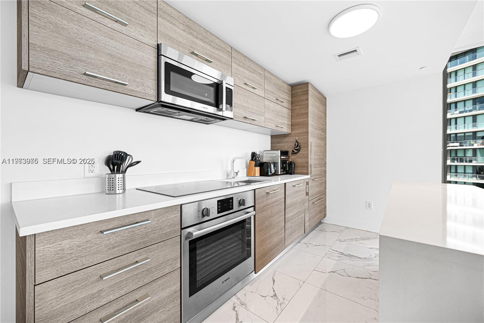 650 Northeast 32nd Street, Unit 2007 Miami, FL 33137 - Photo 4 of 44 a kitchen with stainless steel appliances granite countertop a sink and a stove