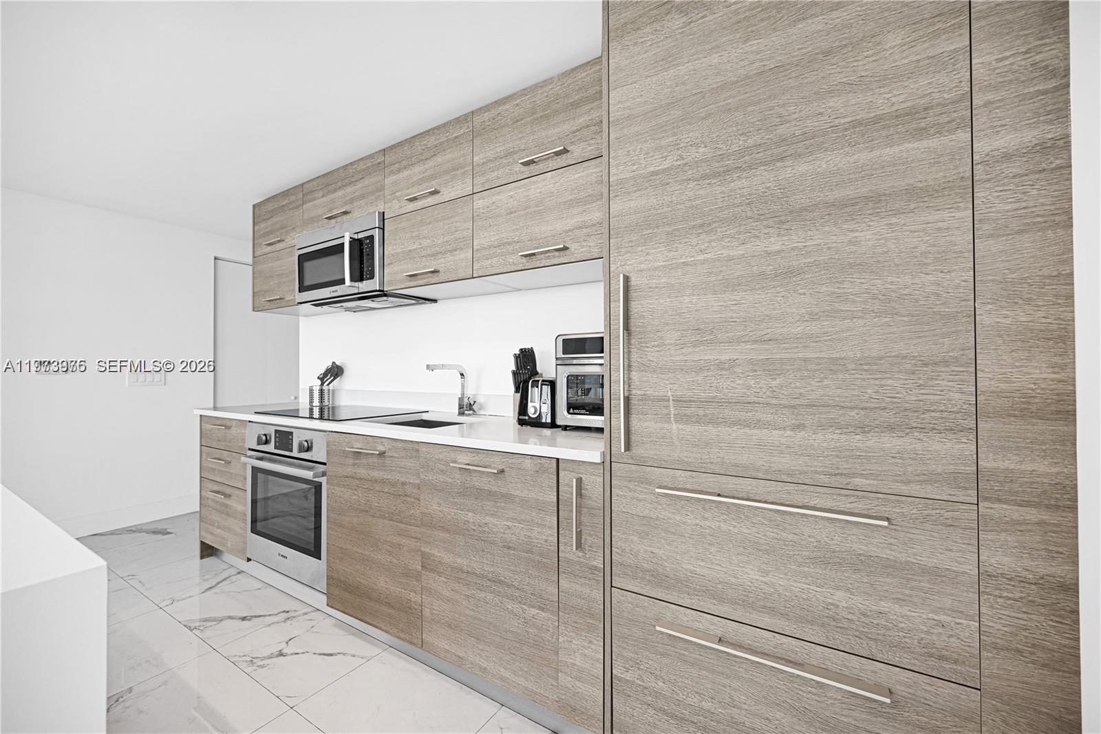 650 Northeast 32nd Street, Unit 2007 Miami, FL 33137 - Photo 5 of 44 a kitchen with stainless steel appliances cabinets and a sink
