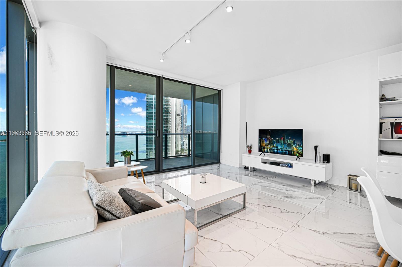 650 Northeast 32nd Street, Unit 2007 Miami, FL 33137 - Photo 6 of 44 a living room with furniture and a flat screen tv