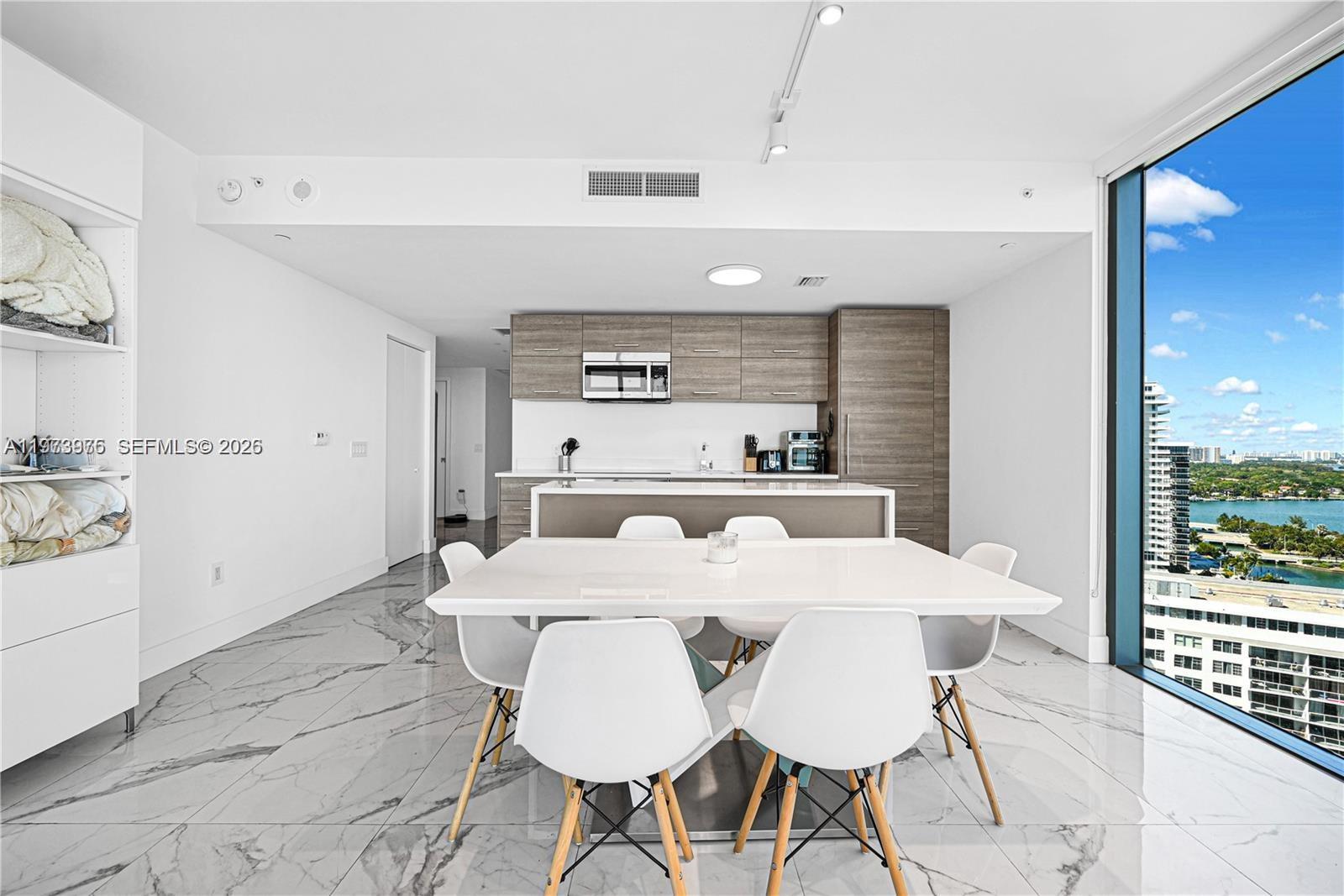650 Northeast 32nd Street, Unit 2007 Miami, FL 33137 - Photo 8 of 44 a large kitchen with a table and chairs
